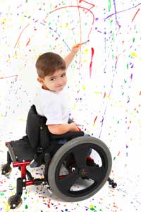 child in wheelchair painting a picture
