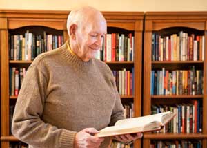 senior man standing and reading