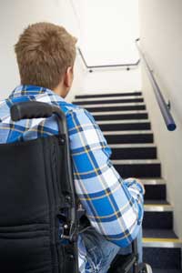 man in wheelchair at foot of stairs