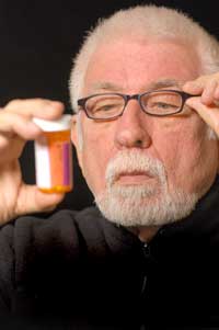 man reading pill bottle